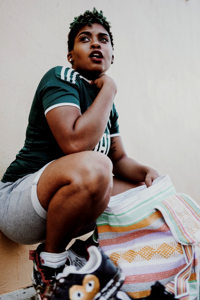 Woman Wearing Green Jersey Holding Multicolored Towel