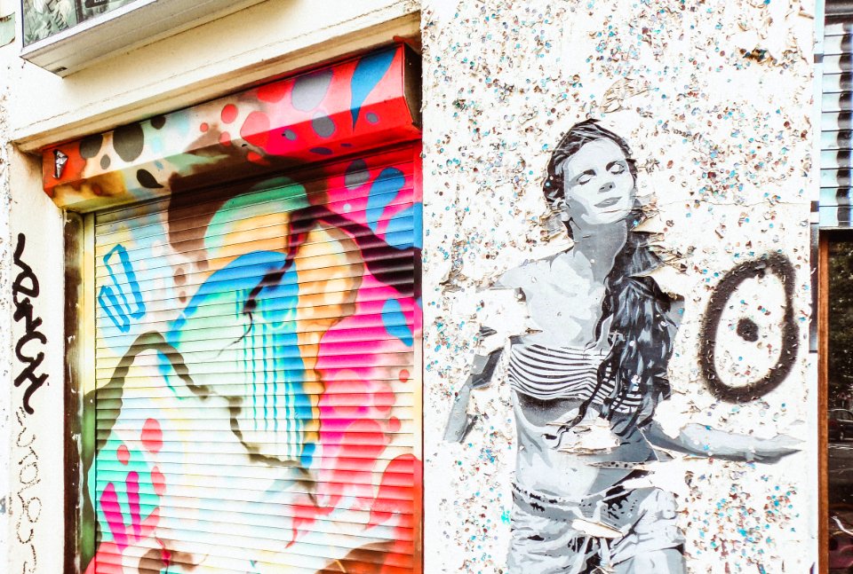 Stencil Art Of Woman On Wall Near Door Shutter With Graffiti