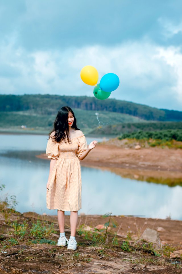 Woman In Beige Off-shoulder Dress Holding Balloons