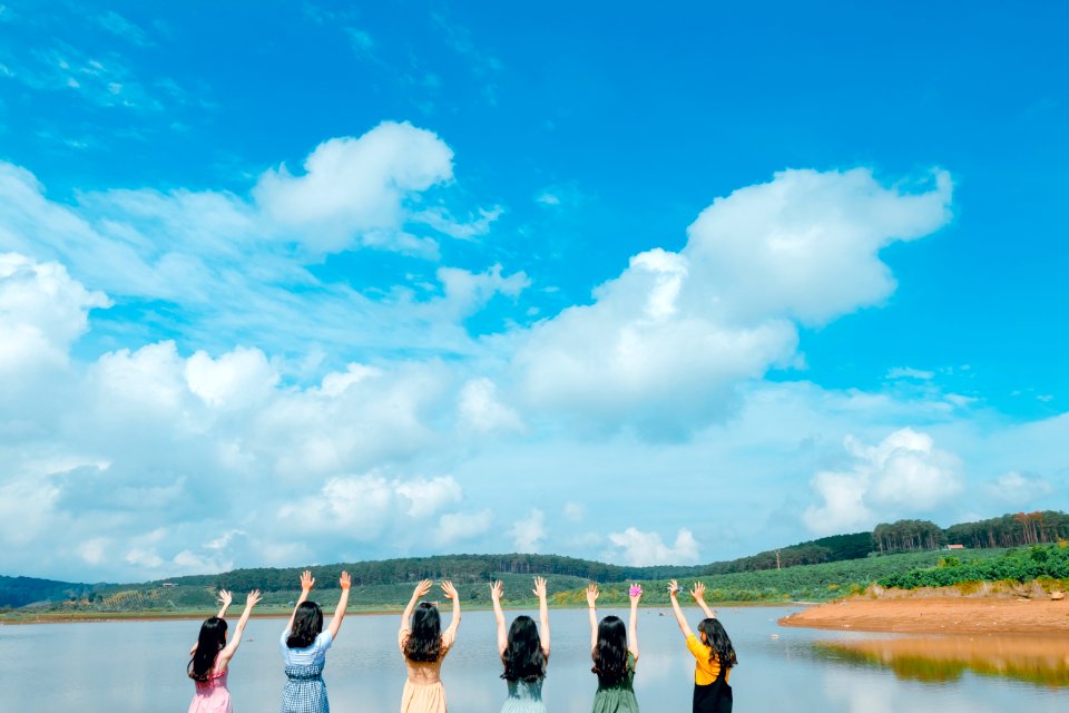Group Of Women Wearing Dress Raising Up Their Hands On Air Under Cloudy Sky