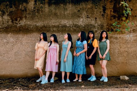 Photography Of Six Girl Standing Beside Wall photo