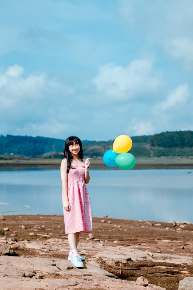 Woman In Pink Dress Holding Balloons
