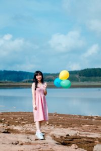 Woman In Pink Dress Holding Balloons photo