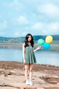 Photo Of Girl Wearing Green Mini Dress Holding Balloons photo