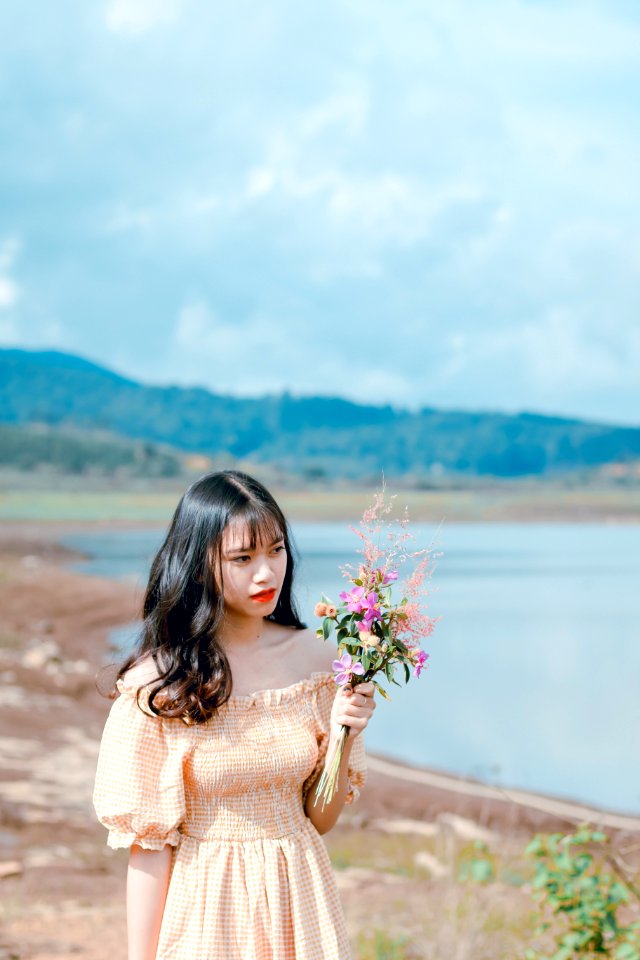 Photography Of A Woman Holding Flowers photo