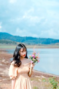 Photography Of A Woman Holding Flowers photo