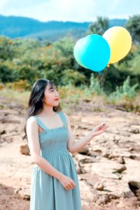 Woman Wearing Blue Dress Holding Balloons