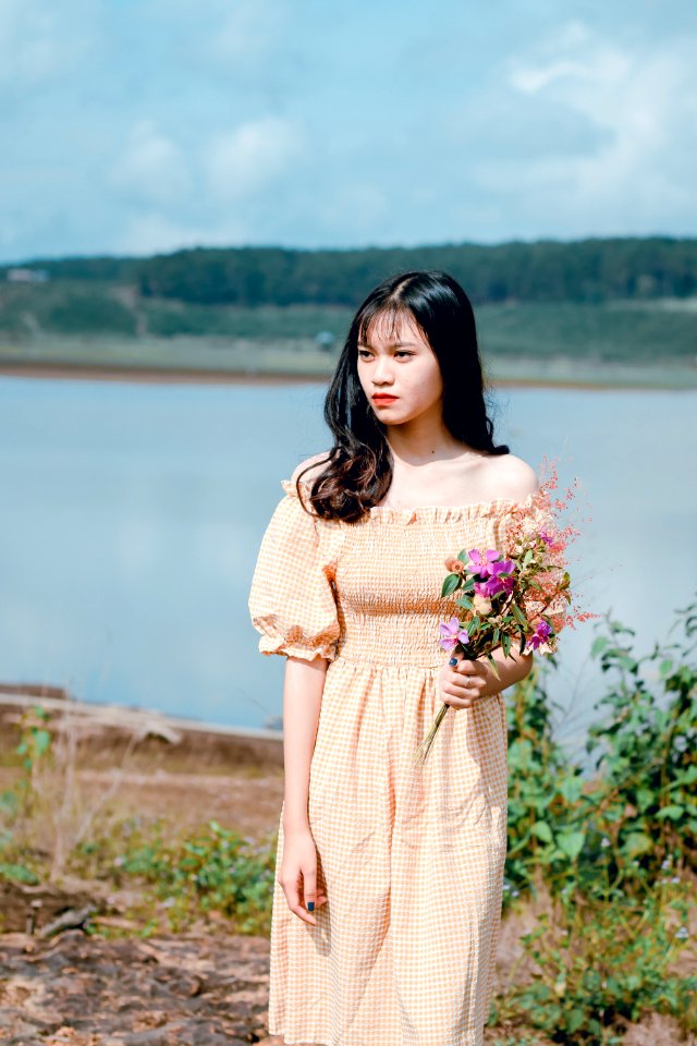 Shallow Focus Photography Of Woman In Yellow Off-shoulder Dress Holding Flower Bouquet