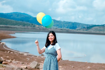 Woman Near Seashore Holding Balloons photo