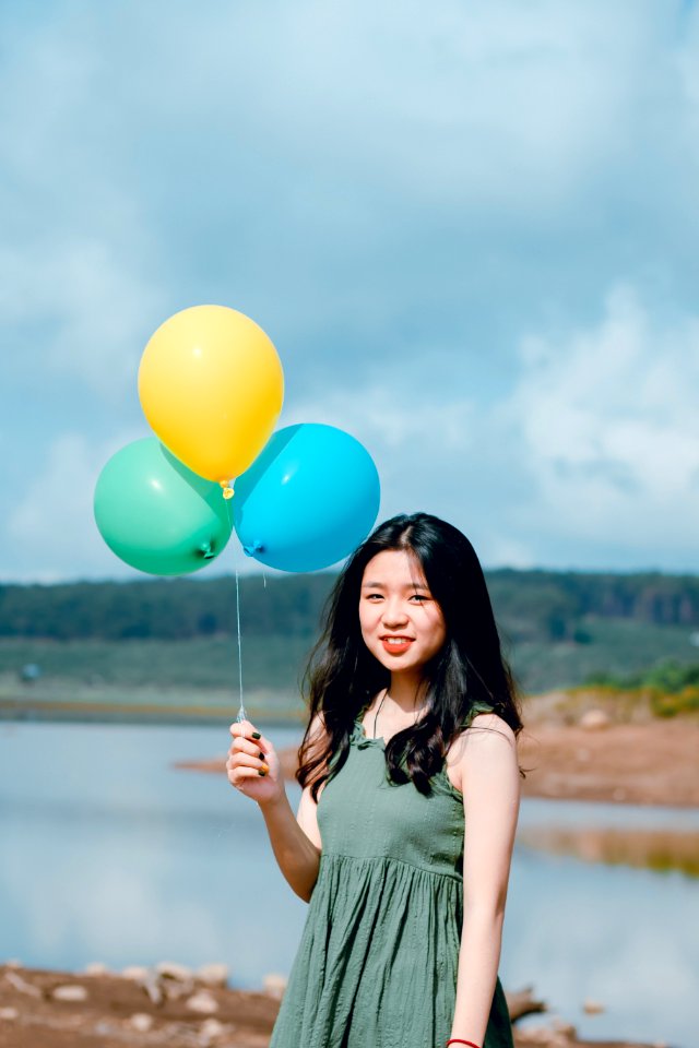 Woman Wearing Green Dress Holding Balloons Near River