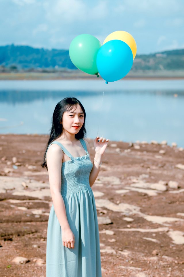 Photography Of A Woman Holding Balloons