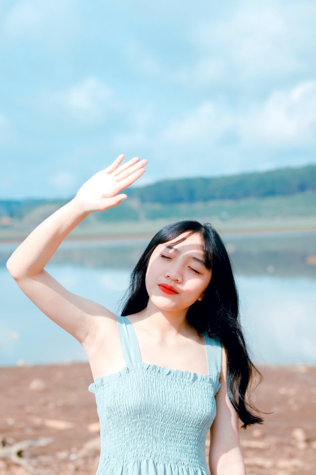 Woman Raising Hand To Cover Sunlight