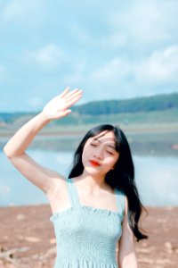 Woman Raising Hand To Cover Sunlight