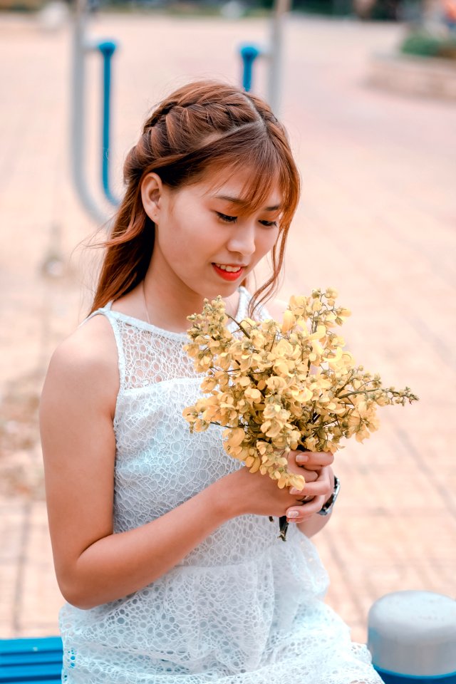 Woman Wearing White Lace Dress Holding Yellow Flower Bouquet