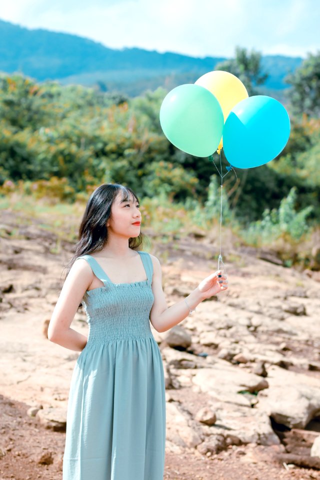 Woman In Dress Holding Balloons