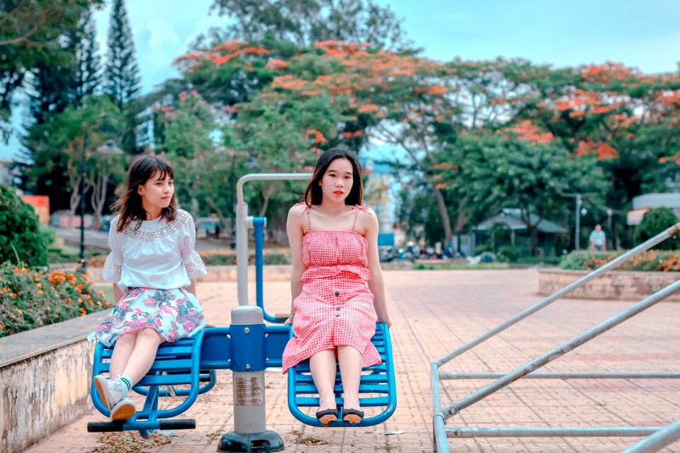 Two Woman Sitting At Park Ride
