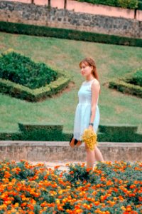 Womens White Sleeveless Dress Holding Yellow Flowers