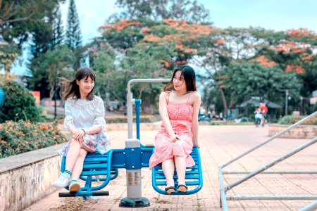 Two Women Sitting In Blue Park Ride photo