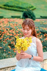 Woman Wearing White Top Holding Yellow Petaled Flowers photo