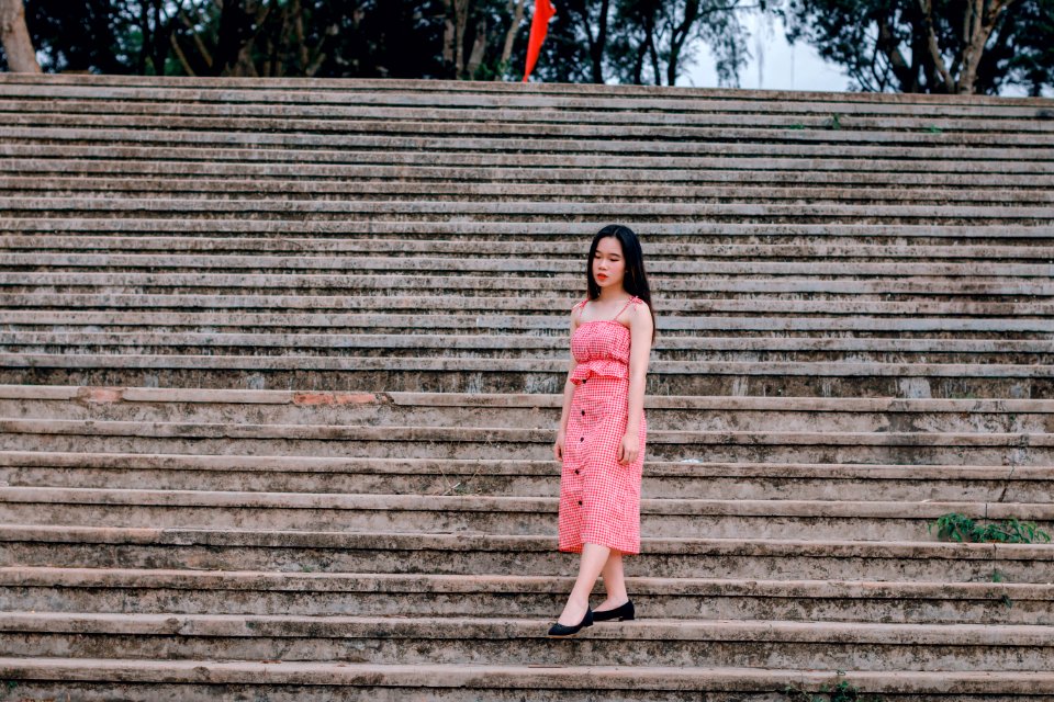 Woman Wearing Pink Spaghetti-strap Dress Standing On Grey Concrete Stairs