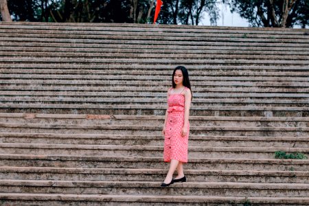 Woman Wearing Pink Spaghetti-strap Dress Standing On Grey Concrete Stairs photo