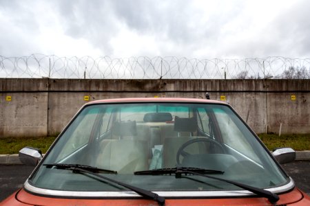 Closeup Photo Of Red Car Near Concrete Wall