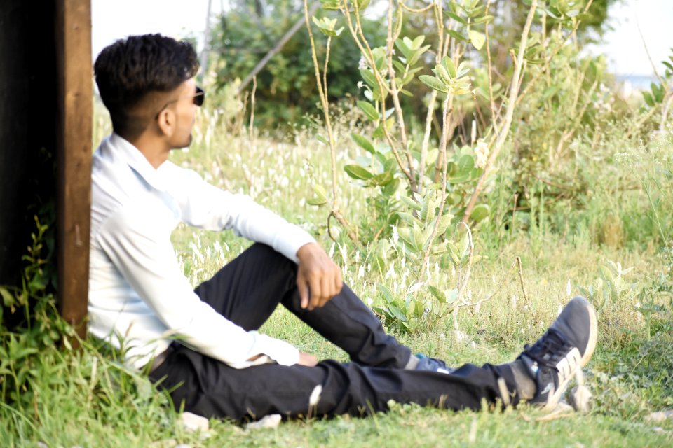 Man In White Long-sleeved Top Sitting On Green Grass photo