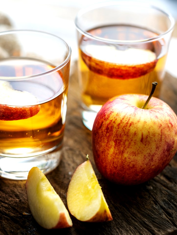 Sliced Apple Beside Two Apple Juice