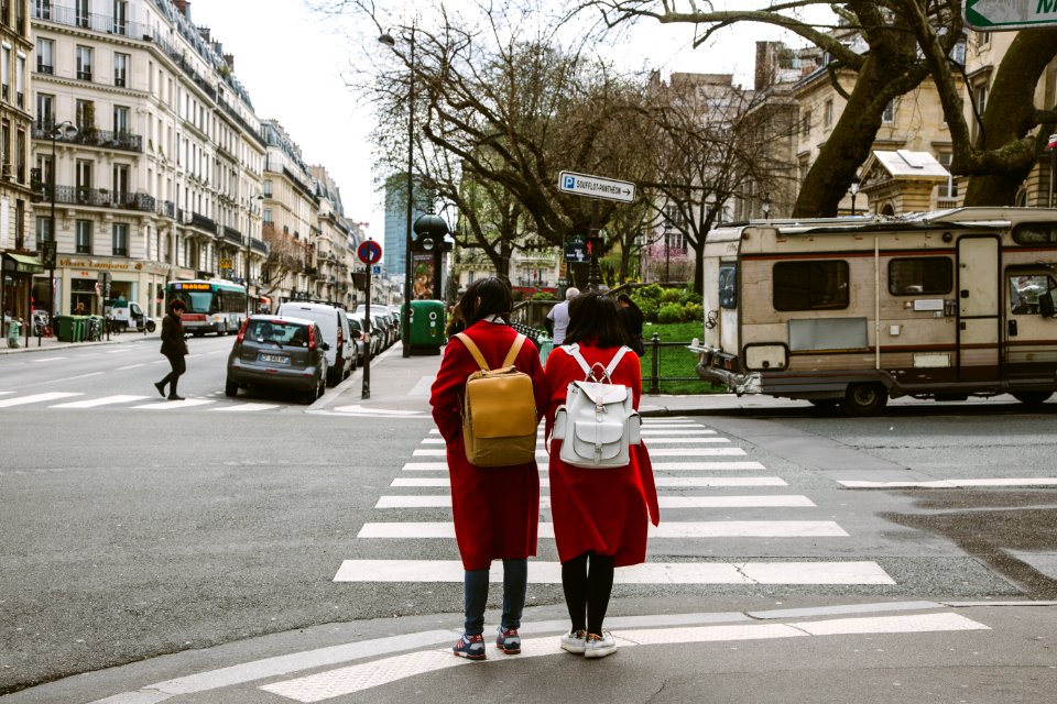 Two Women Wearing Red Coats With Backpacks