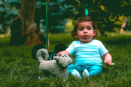 Toddler Wearing Teal T-shirt And Teal Pants Beside Gray Cat Plush Toy
