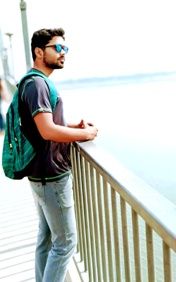 Man Wearing Black Shirt And Blue Denim Jeans Standing On Dock photo