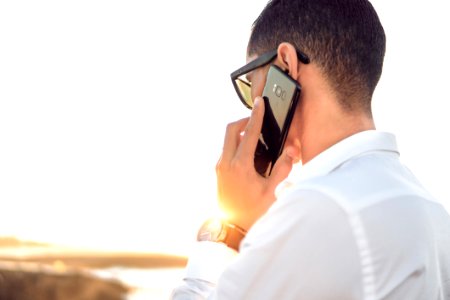 Shallow Focus Photography Of A Man In White Collared Dress Shirt Talking To The Phone Using Black Android Smartphone photo