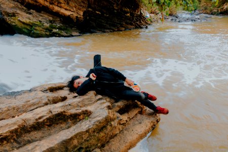 Photo Of Man Lying On Rock At River photo