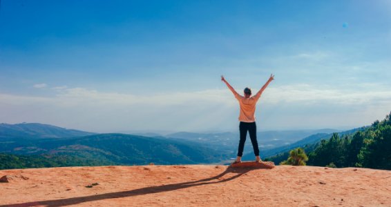 Person In Beige Top On Mountain Cliff