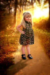 Girl In Black And Pink Floral Sleeveless Dress Stands In Pathway