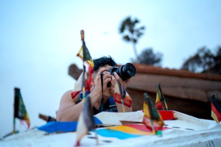 Man Taking Photo Using Dslr Camera Near Country Flag Miniatures photo