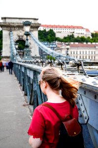 Woman Wearing Brown Leather Backpack Standing On Bridge Photo Taken