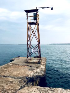 Watch Tower With Lamp Near Body Of Water