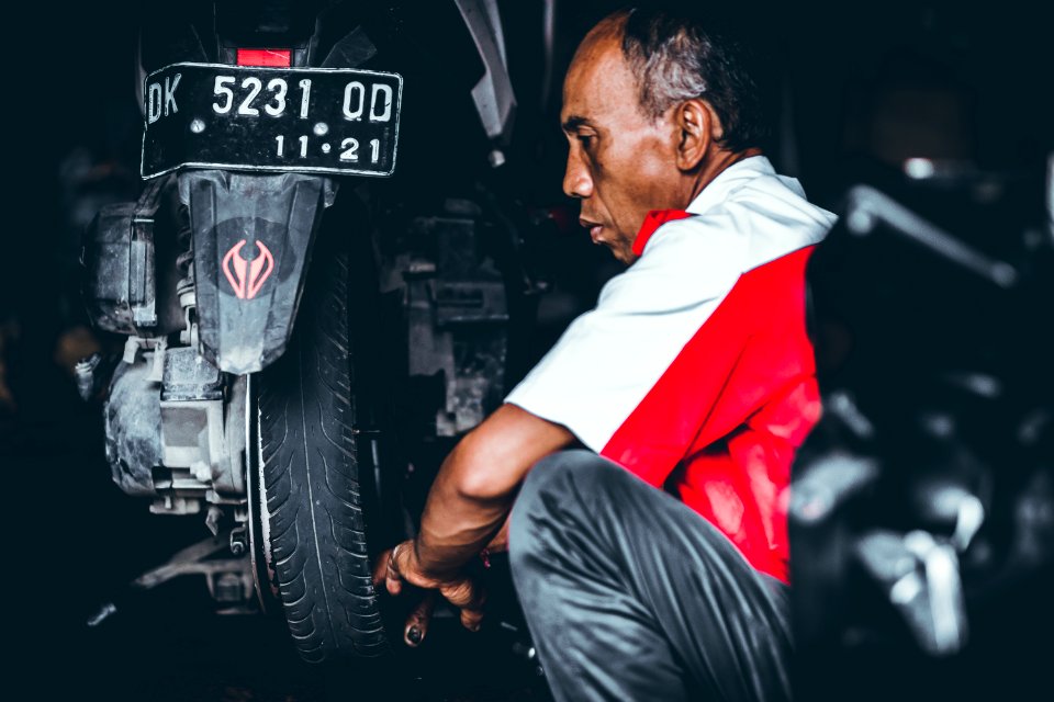 Selective Focus Photo Of Man Looking On Motorcycle