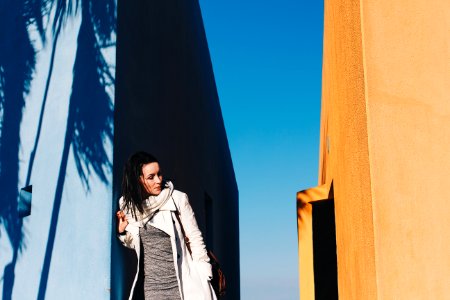 Woman In White Coat Leaning On Wall photo