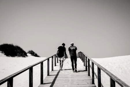 Grayscale Photography Of Man And Woman Crossing Bridge photo