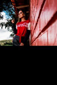 Woman Leaning On Wall Wearing Coca-cola Printed Top photo