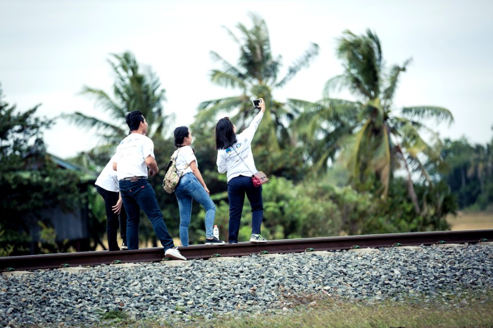 Person Taking A Selfie With Three Persons On Train Railway photo