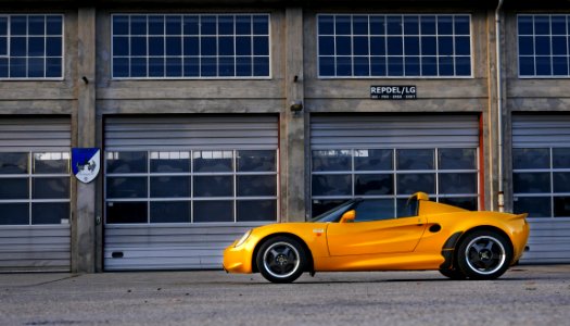 Yellow Coupe Parked Near Brown Painted Warehouse photo