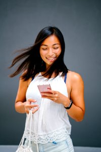 Woman Using A Phone While Carrying A Bag photo