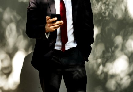 Man Wearing Black Tuxedo Holding Black Smartphone photo