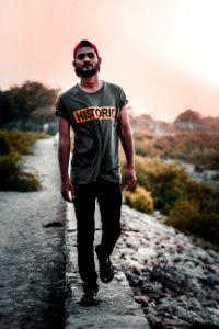 Man In Gray Shirt Standing On Concrete Pathway photo