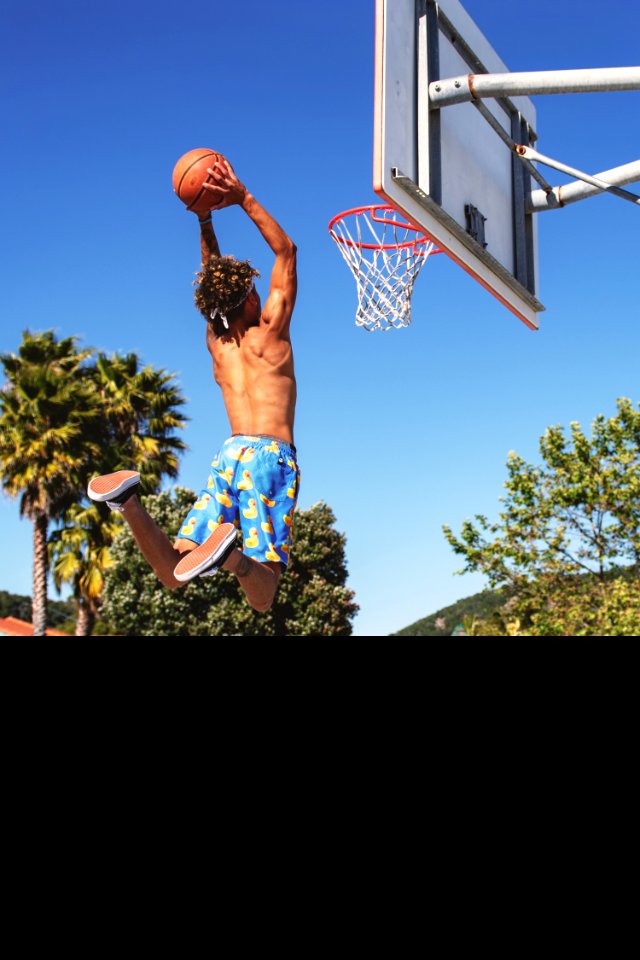 Man Wearing Blue And Yellow Shorts Playing Basketball