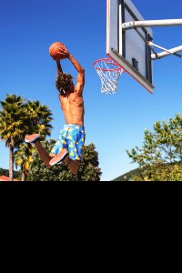 Man Wearing Blue And Yellow Shorts Playing Basketball photo