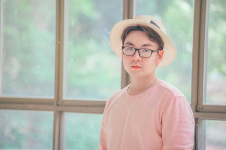 Man Wearing Pink Top Standing Near Glass Panel photo